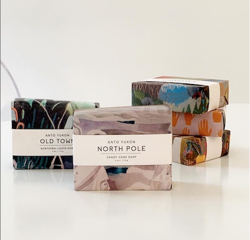 Into Yukon soaps wrapped and stacked; North Pole and Old Town scents