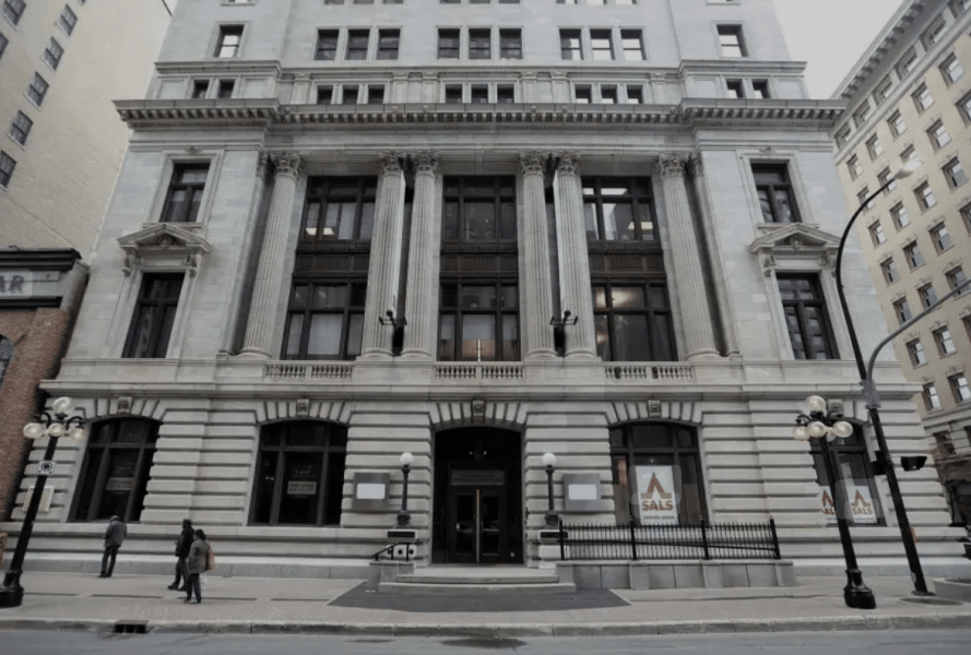 Exterior view of the historic Salisbury House building in Winnipeg's Exchange District, featuring classical architectural elements and passersby.