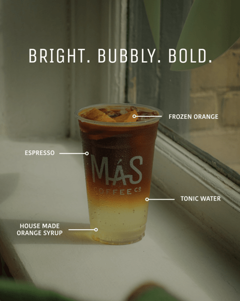 A layered beverage in a cup featuring frozen orange, espresso, house-made orange syrup, and tonic water, showcasing a bright and bubbly drink with a bold appearance.